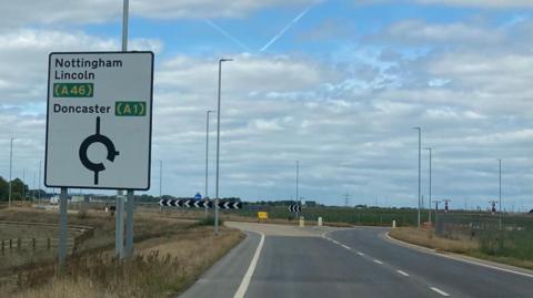 Part of newly built road with sign indication way to A46 and A1