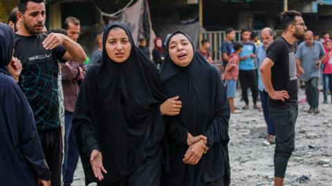 Palestinians react after an Israeli air strike on a UN school in Nuseirat refugee camp, in central Gaza (6 June 2024)