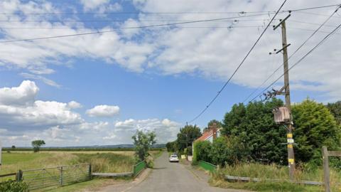 Google street view of Marsh Lane showing where the kittens were found. There is a small green bridge over a waterway with a cottage in the middle distance and fields and a telegraph pole