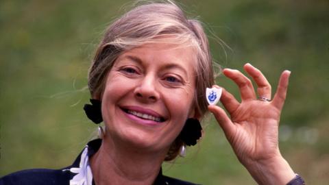 Biddy Baxter holding a Blue Peter badge in 1988.
