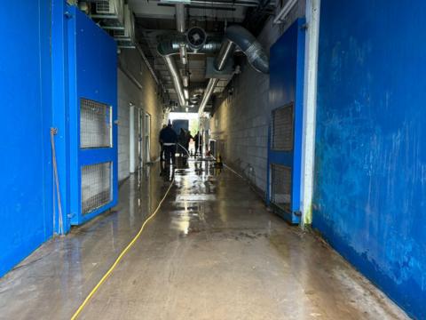 People in high vis work pumps in a flooded corridor at AFC Telford football ground