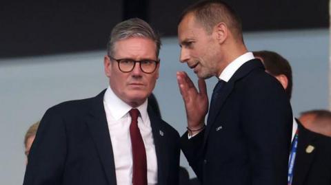 Sir Keir Starmer, Prime Minister of the United Kingdom and Leader of the Labour Party, speaks with Aleksander Ceferin, President of UEFA before the EURO 2024 final match between Spain and England 