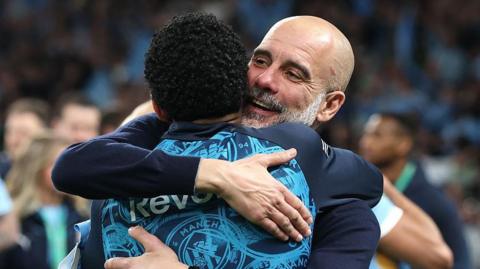 Pep Guardiola hugs his players