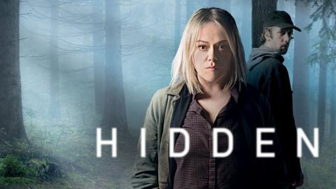 A promo image for the show Hidden of a woman standing in front of a lurking man in a forest 