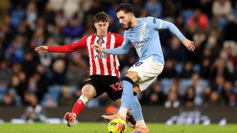 Rayan Cherki of Manchester City is challenged by Trai Hume of Sunderland 