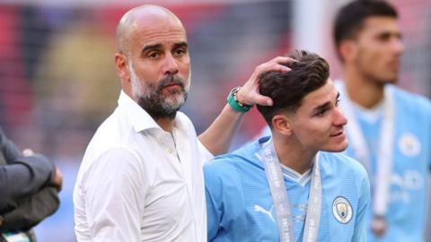 Manchester City boss Pep Guardiola (left) ruffles the hair of striker Julian Alvarez (right)