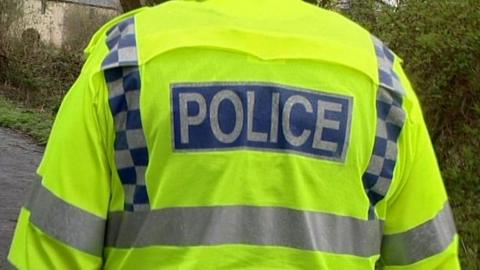 The back of a police officer wearing a police jacket. It says POLICE on the back.