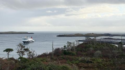 A CalMac ferry at Stornoway on a grey day. The picture is taken from an area of scrubland.