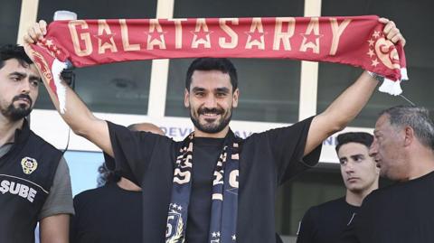 Ilkay Gundogan holds a Galatasaray scarf above his head