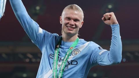 haaland smiling wearing his football kit.