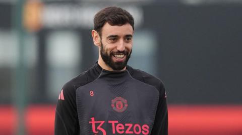 Manchester United's Bruno Fernandes smiles during a training session at Carrington Training Centre.