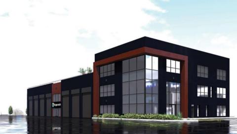 An architect's digital art designs for the modernised bus depot. It is a three-storey building, with lots of glass windows. The majority of the building is black, with some brown decorative accents. There is also some greenery at the base of the corner of the building.