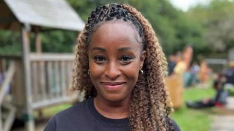 Precious wearing a black T-shirt, smiling for camera.