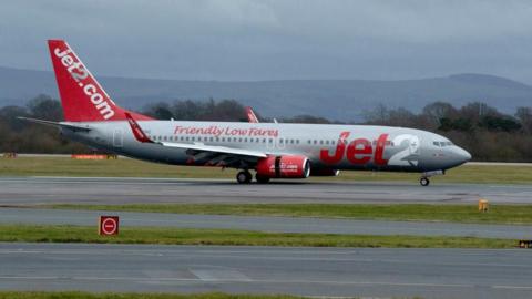 A Jet2 plane is landing on the tarmac at Manchester airport.