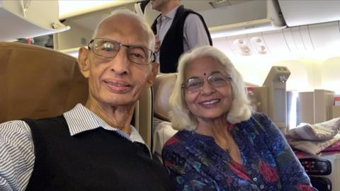 A couple taking a selfie on board a flight