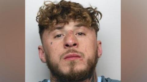 Mugshot of Kai Haddington, with curly brown hair and a beard.