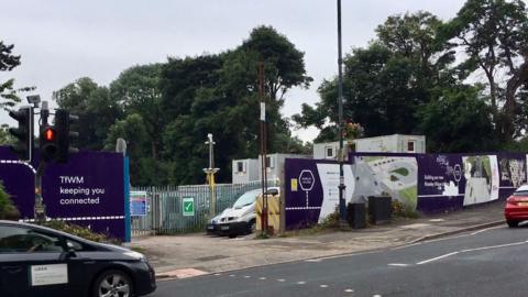 Construction taking place at a railway station - the outside of the station pictured with a purple sign with the words TFWM keeping you connected