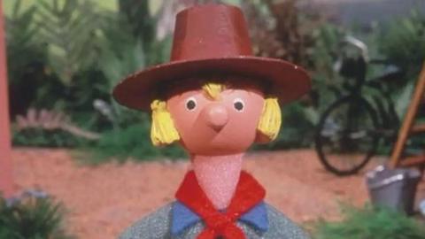Close up image of an animated character with a farmer's hat and blond hair looking to camera. He is Windy Miller from Camberwick Green.