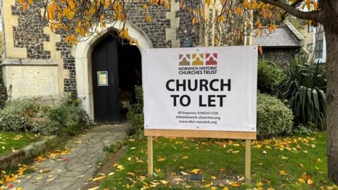 A sign outside St Saviour's Church, stating: "Norwich Historic Churches Trust; Church To Let" with details including phone: 016030 611530, email: info@norwich-churches.org and website: www.nhct-norwich.org