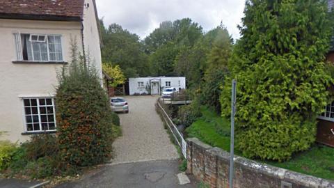 Boxford Mill Surgery is a single story white, timber-clad building down a small lane in a village