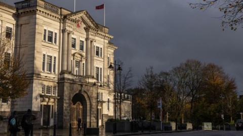 Kent County Council's large stone county hall building in Maidstone, underneath a cloudy sky.