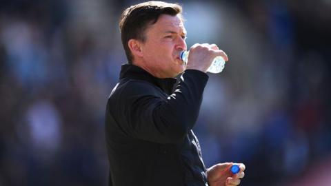 Preston boss Paul Heckingbottom drinking a bottle of water
