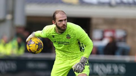 Goalkeeper Joel Coleman underarms the ball out  for Bolton Wanderers