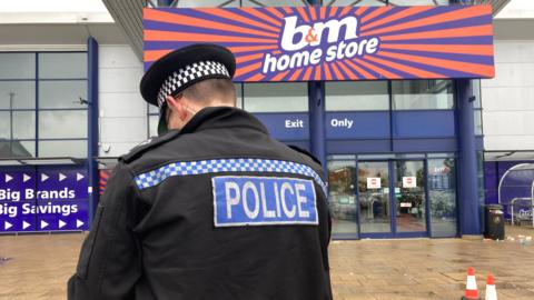 A police officer outside B&M at Riverside in Norwich