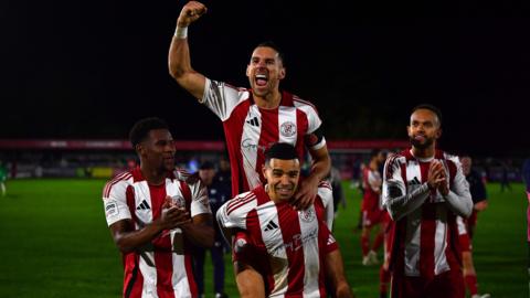 Brackley Town players celebrate beating Notts County in the FA Cup third round