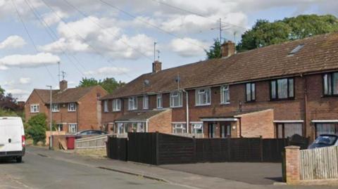 A row of terraced houses in a residential cul-de-sac. 