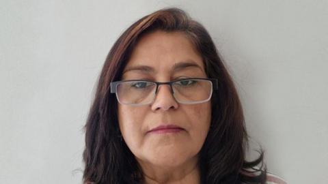 Bindu Parmar, a south Asian woman wearing glasses with shoulder length brown hair