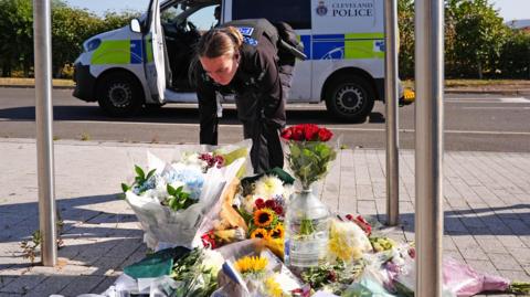 A police officer lays flowers