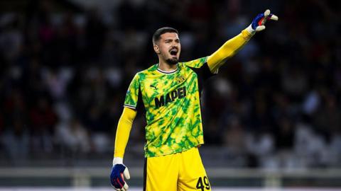 Arijanet Muric in a yellow Sassuolo goalkeeping kit shouts at his defenders during a game