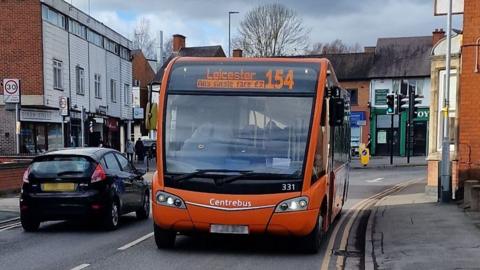 An orange Leicester Centrebus bus on a city street