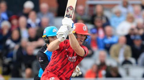 Keaton Jennings batting for Lancashire, with a full flourish of his bat, as the Worcestershire wicketkeeper watches on