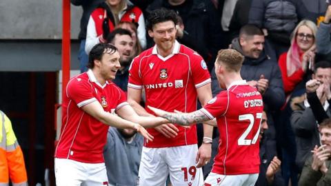 Wrexham's Kieffer Moore (centre) celebrates with Ollie Rathbone (left) and Lewis O'Brien (right)