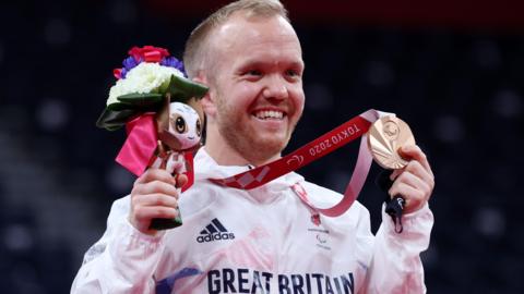 Krysten Coombs holds his Paralympic bronze medal