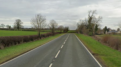 Google street image of a single carriageway road with fields either side.