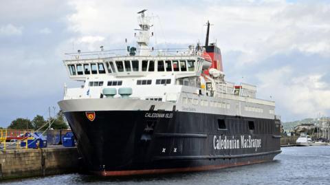 A black and white ship with a red funnel and Caledonian MacBrayne written on the side in white lettering