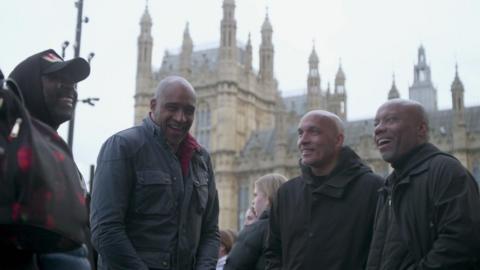 Members of the V11 group standing outside the Houses of Parliament for a campaign march