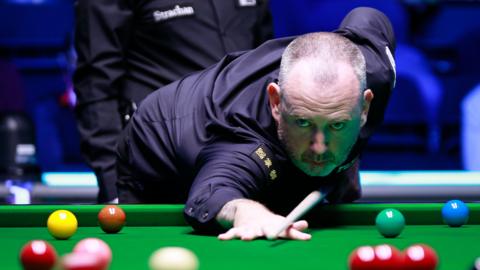 Snooker player Mark Williams takes a shot