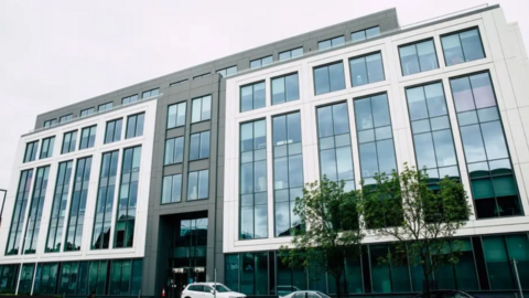 An exterior view of Slough Borough Council offices - a large five storey building, the front is covered with windows and a mixture of white and grey panelling.