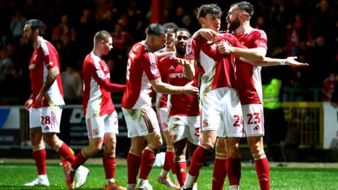 Fletcher Holman celebrates with Swindon Town teammates