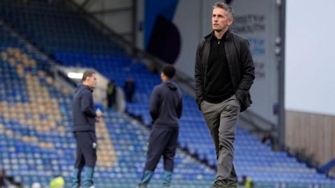 Ipswich boss Kieran McKenna pictured walking across the pitch at Fratton Park 
