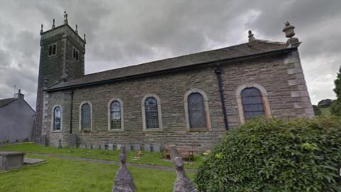 St Anne's is a Georgian single-story grey-bricked church with a two-storey tower on one side.