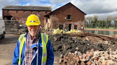 Bernie Jones standing in front of the two warehouses