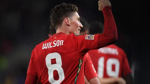 Harry Wilson celebrates scoring for Wales with his back to the camera displaying his name and No.8