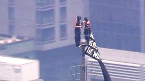 A man and a woman are seen at the top of the Empire State Building.