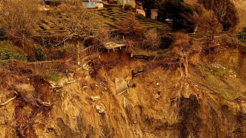 A brown crumbling cliff with a maze visible about 10 metres close to the edge.