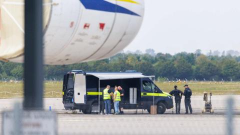 Police investigators work on the tarmac with a robot that is capable, amongst other things, of defusing explosives, near to Ukrainian Antonov cargo plane at Leipzig/Halle Airport on August 5, 2026 near Leipzig, Germany. 